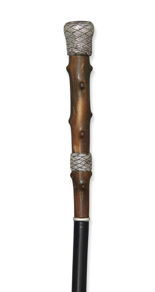 
	
		A silver-mounted horn walking cane, c.1920, with basket-weave grip and collar, the top...