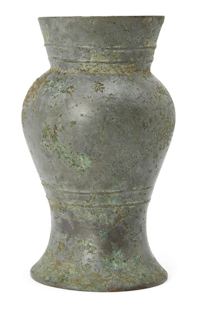 
	
		A Chinese bronze vessel, hu, Shang dynasty, with flared rim and bulbous body to spreading...