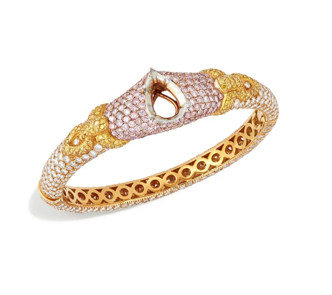 Graff. A diamond and coloured diamond bangle, with a central vacant pear-shaped collet, to...
