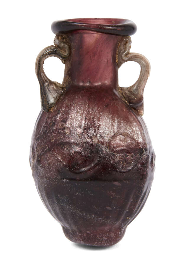 A Sidonian small mould-blown flask,second half of 1st century A.D.,
made in streaky purple glass...