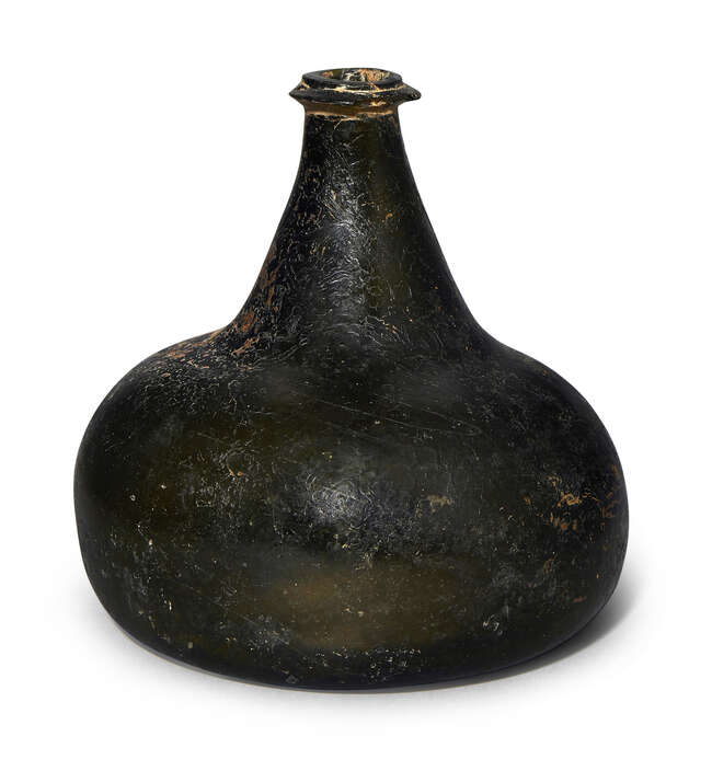 
	
		A dark green glass bottle, late 17th century,  of squat onion form, 15cm high
		