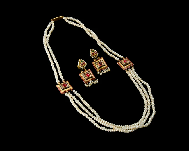 An Indian cultured pearl three strand necklace, together with matching earrings,India, 20th...