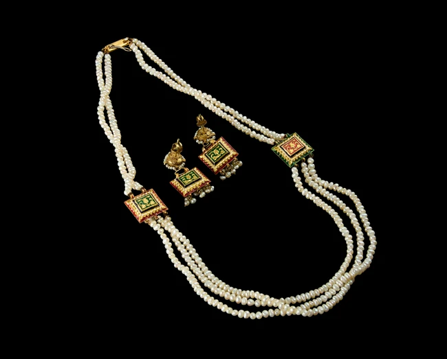An Indian cultured pearl three strand necklace, together with matching earrings,India, 20th...
