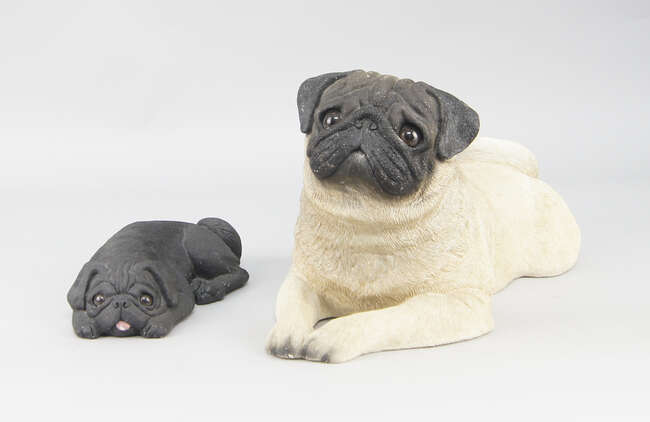 
	
		A large ceramic model of a pug by Sandicast, painted and modelled seated, 42cm long,...