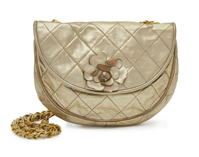 
	
		Chanel: a gold quilted leather half moon shoulder bag, with appliqué camellia flower, 