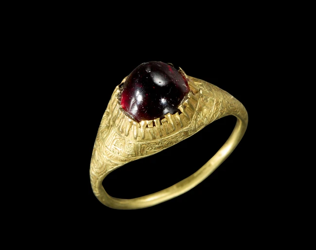 An inscribed gold Seljuq ring set with garnet,11th-12th centuryThe band plain, the bezel with...