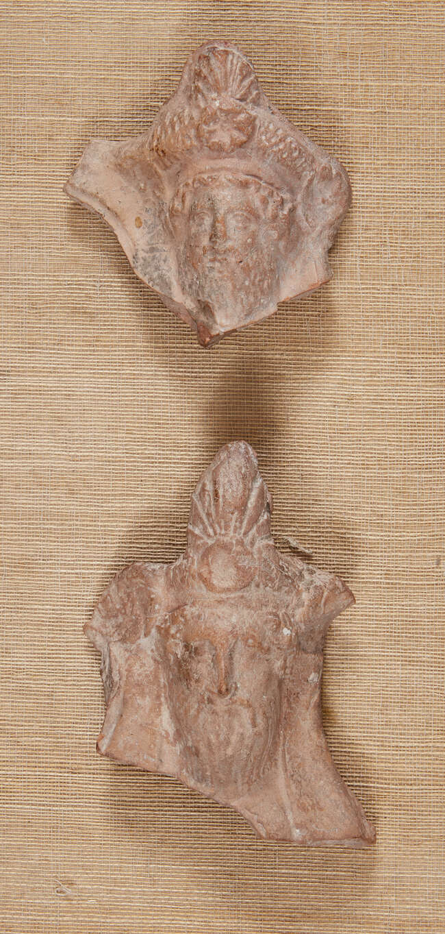 Two Greek terracotta hollow-backed relief fragments, each of a bearded male banqueteer wearing...