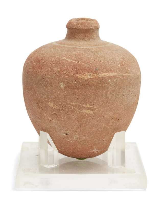 
	
		A Bronze Age buff pottery vessel 
		Circa 1500-1200 B.C.
		With bulbous tapering body,...