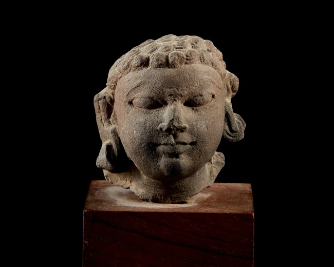 A fragmentary sandstone head, India, Gupta period, circa 4th century, 
with bulging almond...