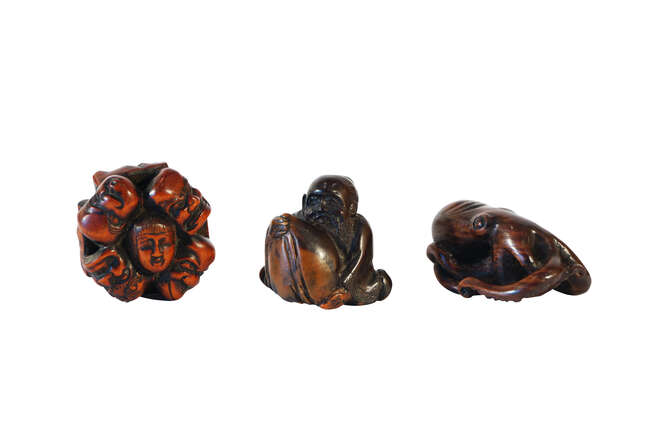 
	
		Three Japanese wood netsuke, 19th century, including; an octopus, a cluster of noh masks,...