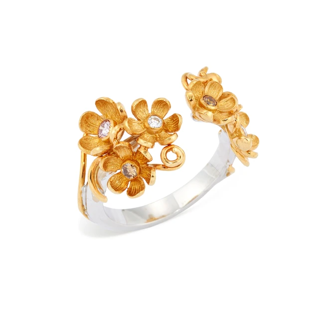 A diamond and coloured diamond torque ring, the terminals designed as floral clusters set with...