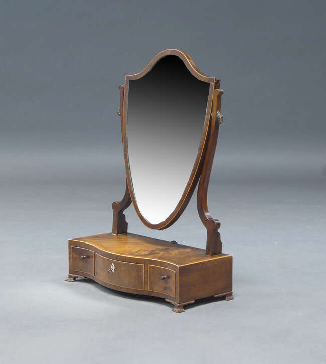 
	
		A George III mahogany and crossbanded dressing table mirror, the shield shaped mirror on...