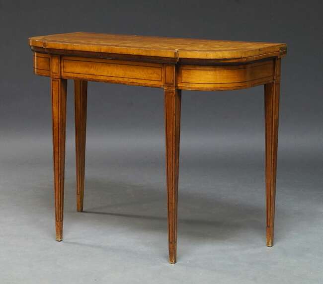 
	
		A George III satinwood and ebony lined inlaid card table, the fold over top enclosing...