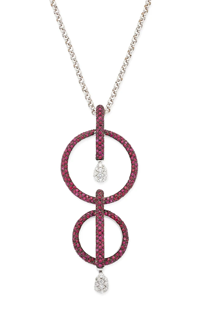 A diamond and ruby necklace, the pendant composed of two ruby set discs, each with a ruby set...