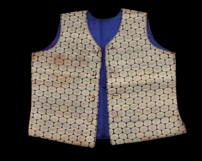 A small embroidered waist coat,India, 
yellow metal thread medallions against black, lined in...