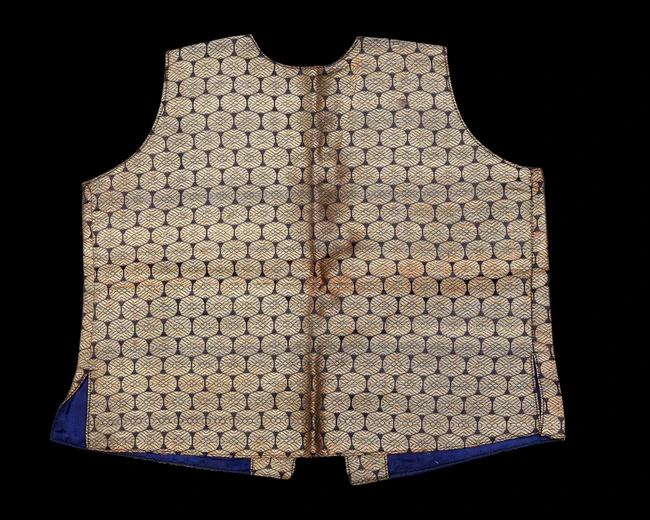 A small embroidered waist coat,India, 
yellow metal thread medallions against black, lined in...