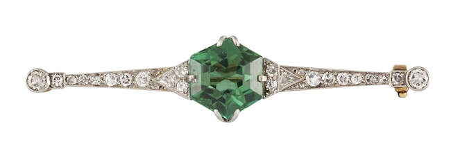 
	
		An Art Deco tourmaline and diamond bar brooch, the central hexagonal green tourmaline to...