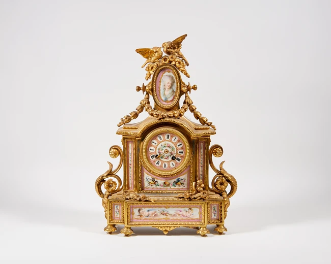 A Sevres style spelter and porcelain mantle clock, late 19th century, the porcelain Roman dial...