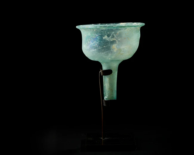 A Byzantine pale blue glass stemmed lamp insertcirca 6th Century A.D.,
With stand,
10.5cm...