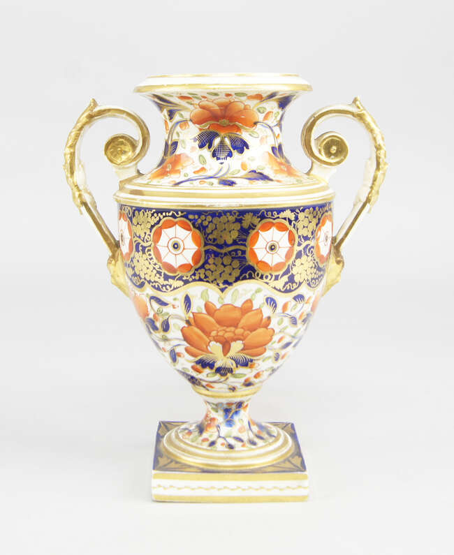
	
		A Derby porcelain twin handled urn, 19th century, decorated in the Imari palate, on a...