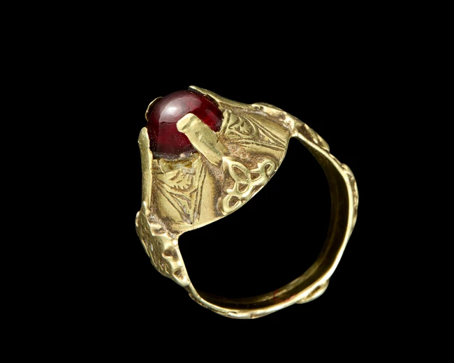 A Seljuq gold ring set with a garnet,13th centuryThe band with raised strapwork detail, the...