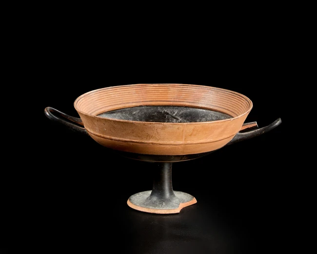 An Attic black-figure lip-cup,mid-6th Century B.C,
decorated with a band of black around the lip...