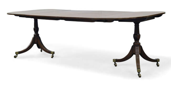 
	
		A George III twin pedestal dining table, the rounded rectangular top with two additional...