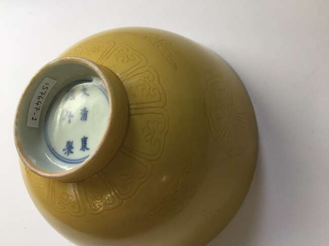 
	
		A Chinese porcelain incised yellow-glazed bowl, Kangxi mark and of the period, incised to...