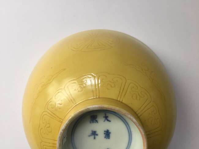 
	
		A Chinese porcelain incised yellow-glazed bowl, Kangxi mark and of the period, incised to...