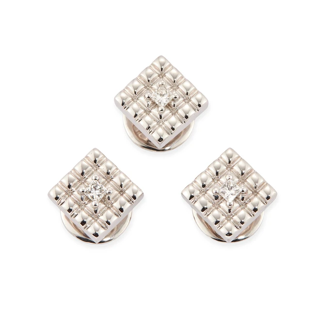 A group of three dress studs, each of square form, with grooved pattern, set with a princess-cut...
