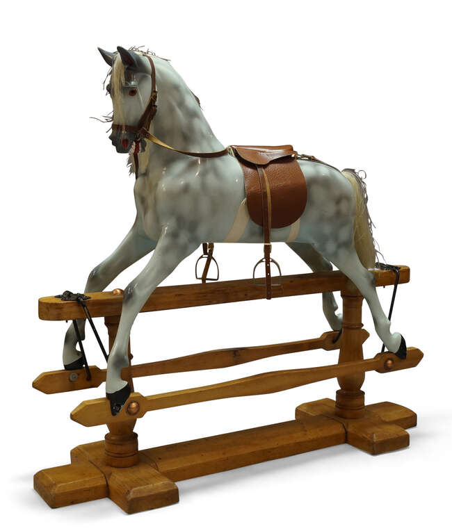 
	
		A dapple grey painted rocking horse, late 20th century, the horse with leather saddle and...