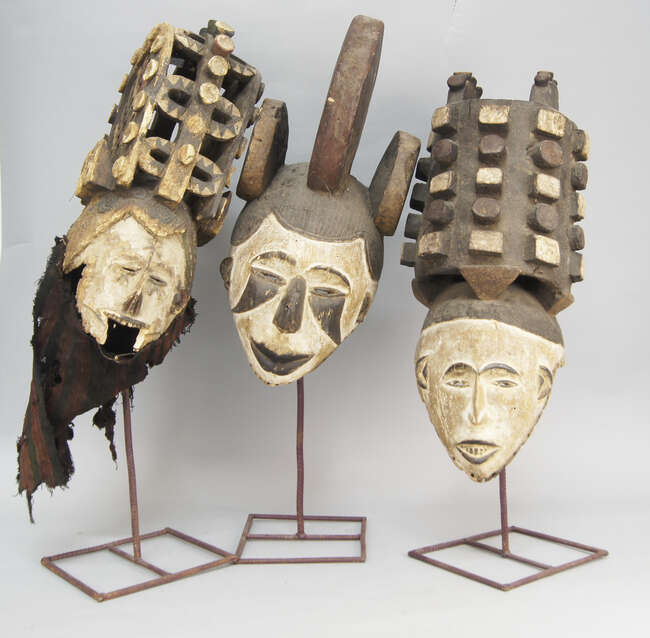 
	
		A group of three tribal masks, possibly Igbo, two with elaborate geometrically carved...