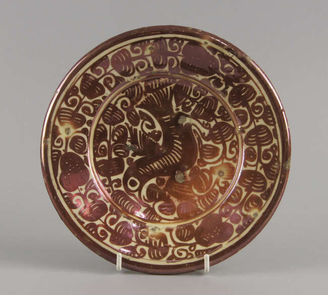 
	
		A Hispanio Moresque pottery plate, 19th century, gilded with a bird within scrolling...