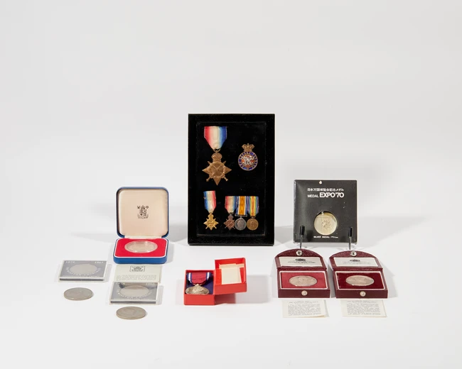 A display cased fitted with various medals and badges comprising: the 1914-15 Star, awarded to...