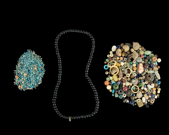A quantity of Egyptian blue and white faience miniature beads and five red and cream faience...