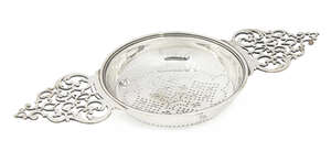 A mid 18th century silver lemon strainer, makers mark for William Soloman c.1754 (no hallmarks) with open scrollwork handles, the bowl 10.6cm diameter, 14.2cm 