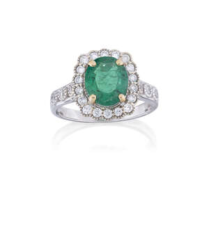 
	
		An emerald and diamond cluster ring, the oval emerald, weighing approximately 2.11...