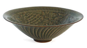 A Chinese Yaozhou conical bowl, carved in low relief to the interior with two entwined flowering peony stems, with wrythen fluting to the exterior, all covered