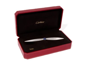 Cartier. A paper knife, in the form of a propeller, with central blue lacquer cabochon, signed...