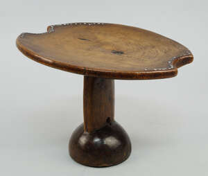 
	
		An Ethiopian head rest, with circular top ornamented with steel nail heads, on a...