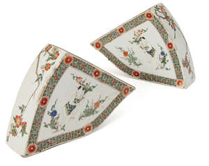 A pair of Chinese porcelain famille verte tile fittings, Kangxi period, each painted to the central reserve with a boy holding a flowering lotus stem, inside a