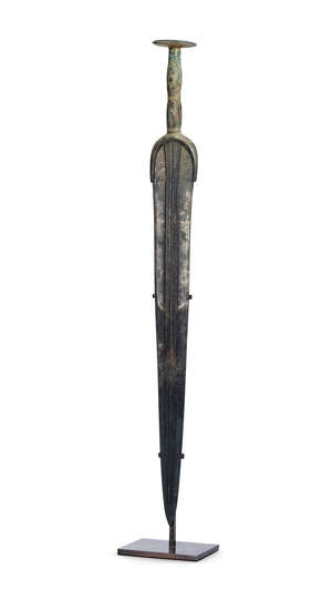 A Luristan bronze dagger, 1st millennium B.C., the blade with three central ridges, with applied bosses to hilt, 57cm. long
		 
		Provenance: Private collec