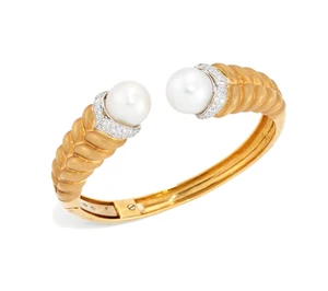 A cultured pearl and diamond torque bangle, the terminals set with a South Sea cultured pearl,...
