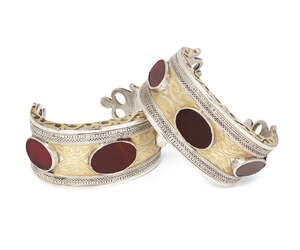 
	
		A pair of small Turkoman Tekke brass and silver cuffs, with openwork terminals, the main...