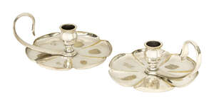 Benson, a pair of silver plated brass chamber sticks
		Early 20th Century, stamped 'Benson' in a rectangle
		Each having a centred sconce and curled 