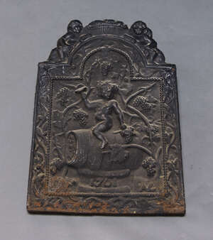 
	
		A cast iron fire back, moulded with a scene of the young Bacchus seated on a barrel...
