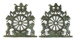 A pair of bronze horse-bits depicting the Master of Animals , 1st millennium B.C., the two cheek-pieces cast in the form of a wheel atop two recumbent lions, t