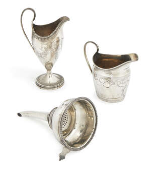 A George III silver helmet shape cream jug, London c.1785, engraved with garlands, 16.5cm high, together with George III silver milk jug, London c.1793 and a D