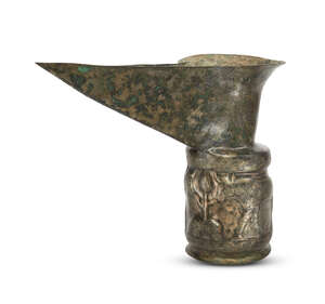 An Amlash spouted high tin bronze ritual vessel with bulls in relief, 1st millennium B.C., of cylindrical form, with splayed foot, the trumpet-shaped neck with