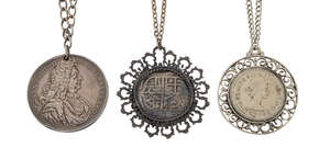 Three coin pendant necklaces, comprising: a pendant mounted reproduction 8 reale coin; a pierced commemorative medallion dated 1694, commemorating Louis IV of 